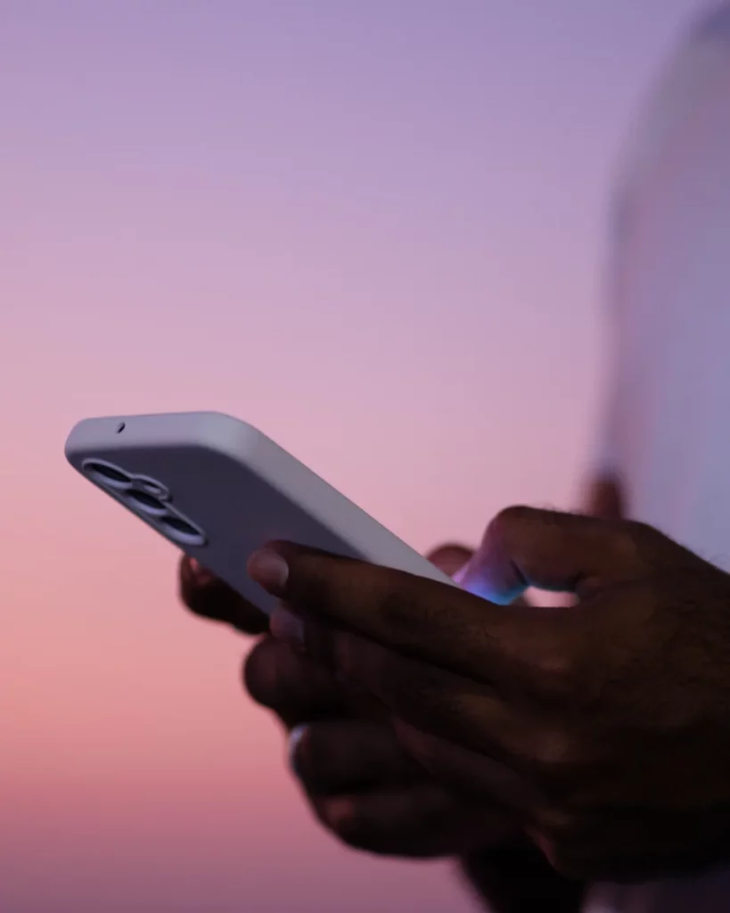 Clinician reviewing healthcare information on a phone at sunset